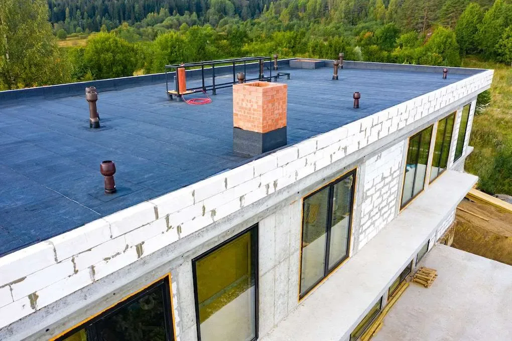 Flat roof membrane installation in progress on a commercial building