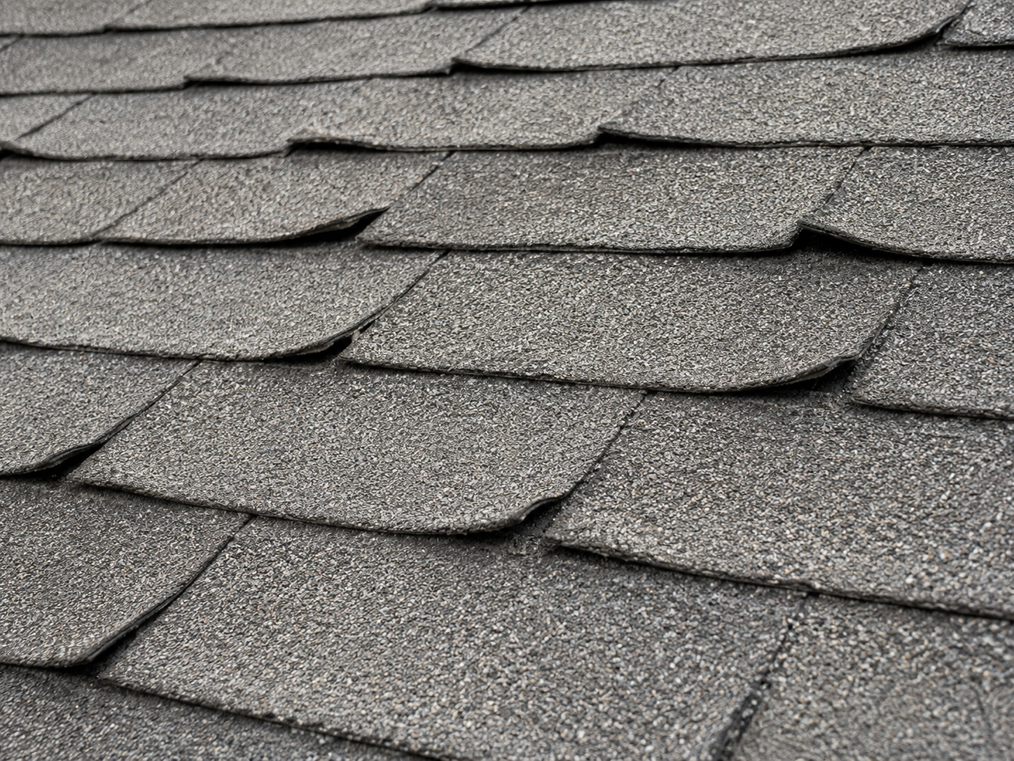 Worn, curling shingles seen up close
